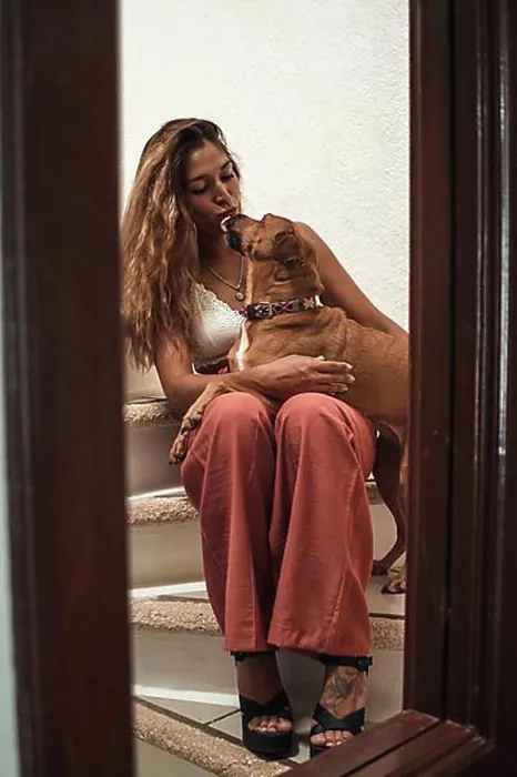 Framed Print : Beautiful young latina hugging her dog showing her affection on the stairs of her house. Love for animals Framed Print : Beautiful young latina hugging her dog showing her affection on the stairs of her house. Love for animals