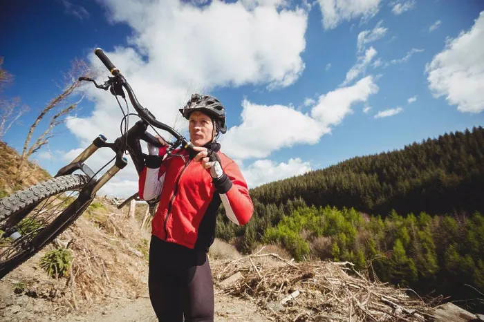 Framed Print : Biker carrying bicycle on mountain against sky