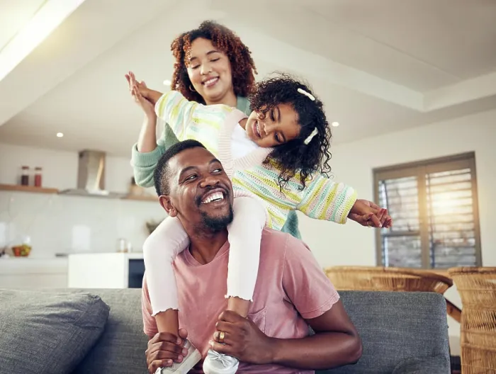 Framed Print : Black family, father and daughter playing with mother on living room sofa together for fun bonding at home Framed Print : Black family, father and daughter playing with mother on living room sofa together for fun bonding at home