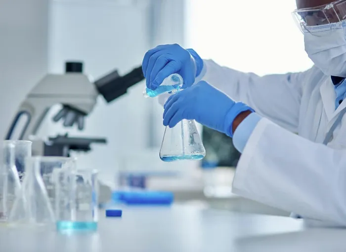 Framed Print : Black person, scientist and liquid in beaker for testing
