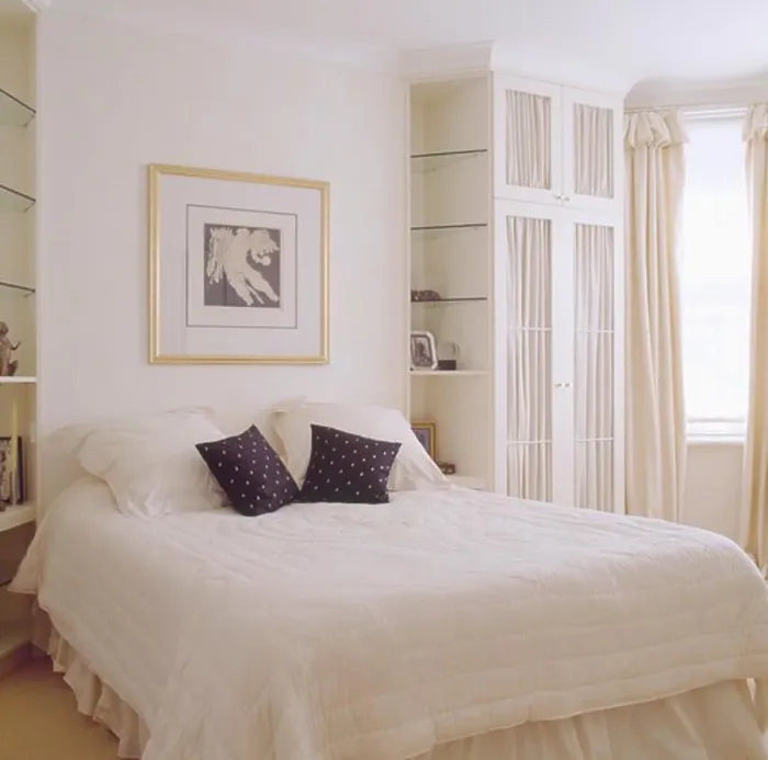 Framed Print : Black and white cushions on white quilt on bed in modern white bedroom with built in wardrobe and shelves Framed Print : Black and white cushions on white quilt on bed in modern white bedroom with built in wardrobe and shelves