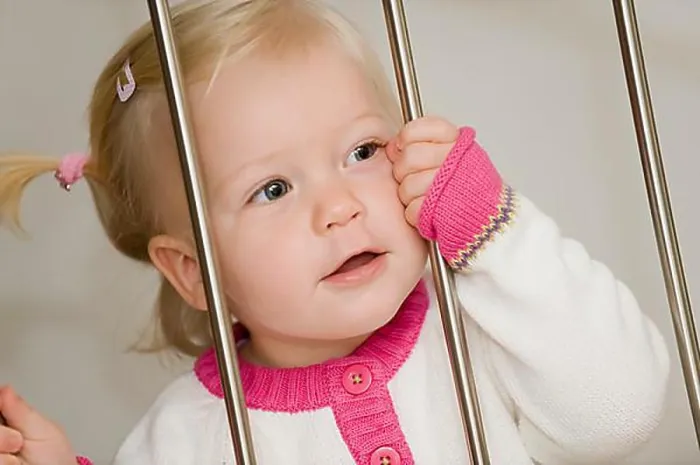 Framed Print : Blonde, 1-year old girl, behind bars Framed Print : Blonde, 1-year old girl, behind bars