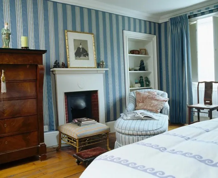 Framed Print : Blue striped wallpaper in townhouse bedroom with chaiselongue beside fireplace