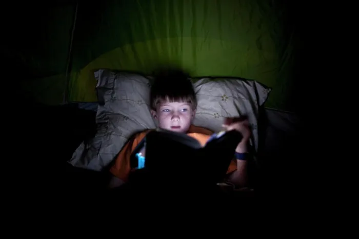 Framed Print : Boy, 9, reading in camping tent by light Framed Print : Boy, 9, reading in camping tent by light