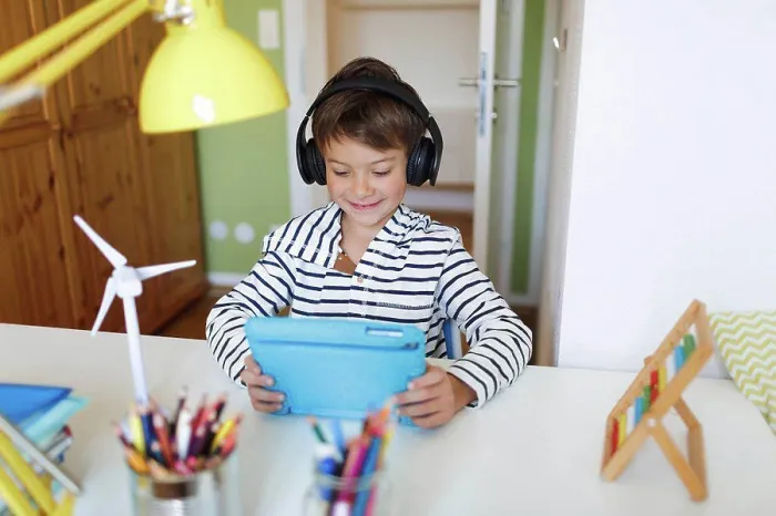 Framed Print : Boy doing homeschooling and using tablet and headphones at home Framed Print : Boy doing homeschooling and using tablet and headphones at home