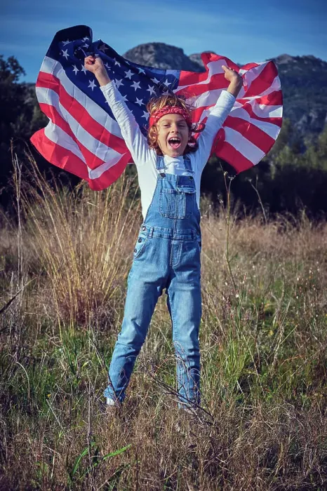 Framed Print : Boy in nature holding an American flag Framed Print : Boy in nature holding an American flag
