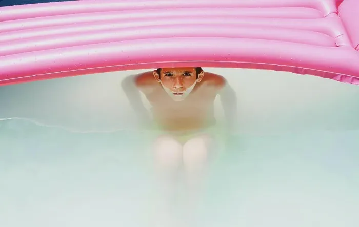 Framed Print : Boy in a pool taking a bath under a pink flat looking at camera Framed Print : Boy in a pool taking a bath under a pink flat looking at camera