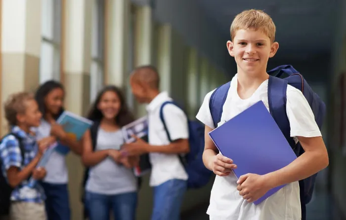 Framed Print : Boy, portrait and smile in corridor of school with backpack and books for learning Framed Print : Boy, portrait and smile in corridor of school with backpack and books for learning