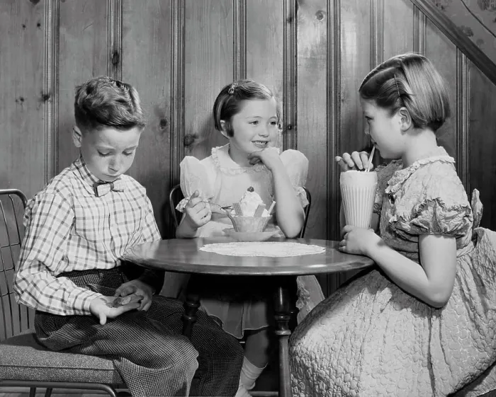 Framed Print : Boy sitting with two girls in a restaurant and counting money Framed Print : Boy sitting with two girls in a restaurant and counting money