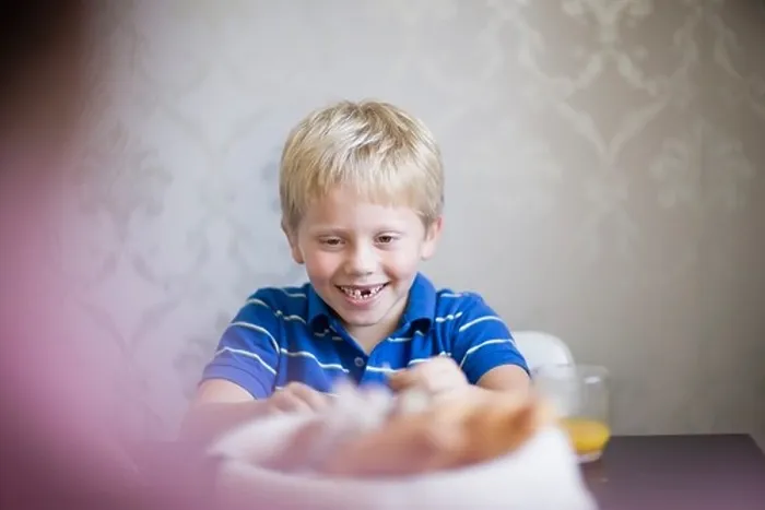 Framed Print : Boy smiling at dinner table Framed Print : Boy smiling at dinner table