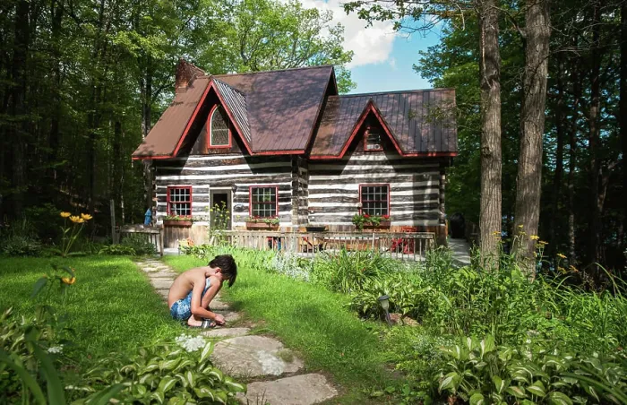 Framed Print : Boy squatting on a path to a log cabin cottage on a summer day Framed Print : Boy squatting on a path to a log cabin cottage on a summer day