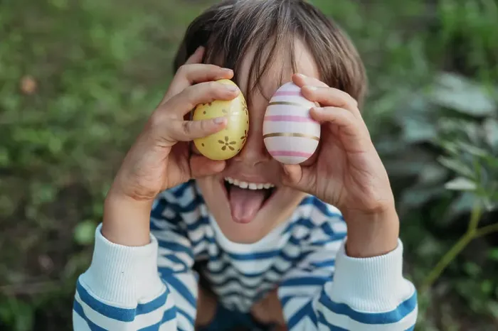 Framed Print : Boy sticking out tongue and cover eyes with easter eggs in park Framed Print : Boy sticking out tongue and cover eyes with easter eggs in park