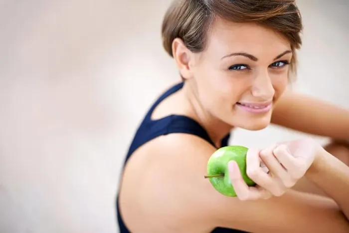 Framed Print : Building blocks for a happy healthy life. a sporty young woman sitting on a gym floor eating an apple