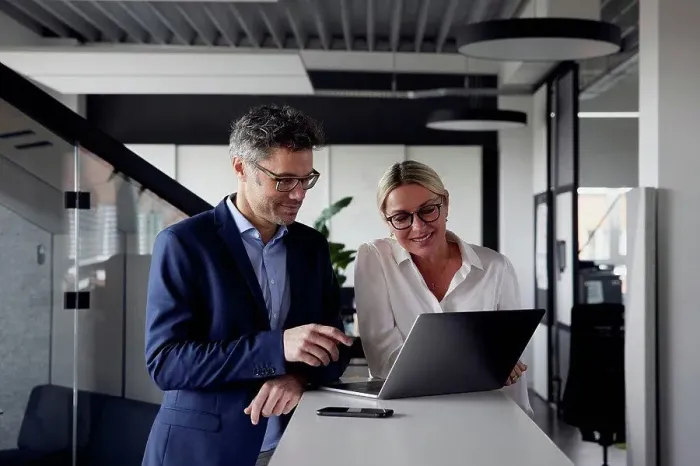 Framed Print : Business colleagues sharing laptop at office
