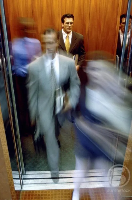 Framed Print : Businessman and a businesswoman exiting an elevator Framed Print : Businessman and a businesswoman exiting an elevator