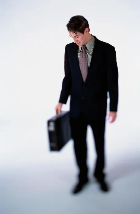 Framed Print : Businessman looking down while holding a briefcase Framed Print : Businessman looking down while holding a briefcase