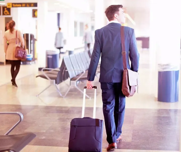 Framed Print : Businessman walking with wheeled suitcase in airport, rear view Framed Print : Businessman walking with wheeled suitcase in airport, rear view