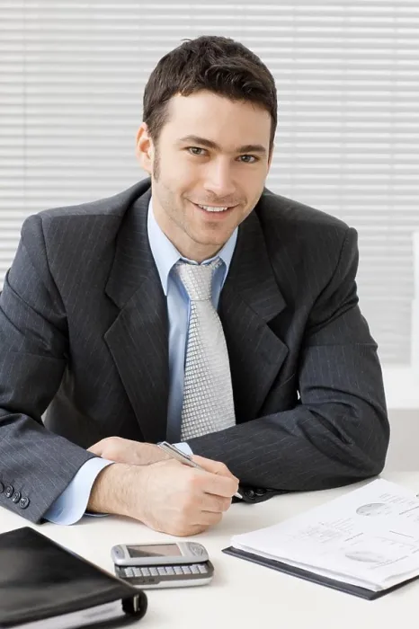 Framed Print : Businessman working at desk Happy young businessman working at desk at office Framed Print : Businessman working at desk Happy young businessman working at desk at office