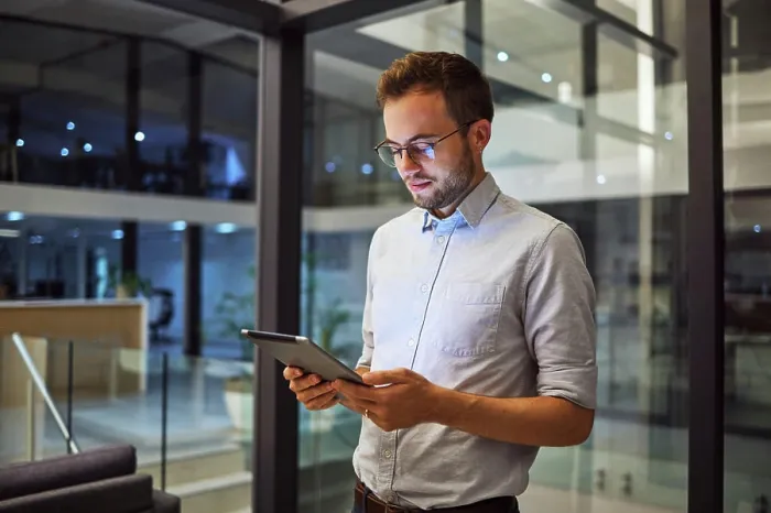 Framed Print : Businessman working on tablet at night for digital marketing online report at the office