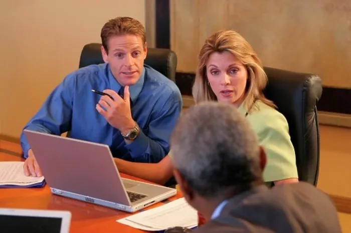 Framed Print : Two businessmen and a businesswoman sitting in a conference room Framed Print : Two businessmen and a businesswoman sitting in a conference room