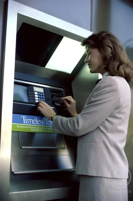 Framed Print : Businesswoman operating an ATM Framed Print : Businesswoman operating an ATM