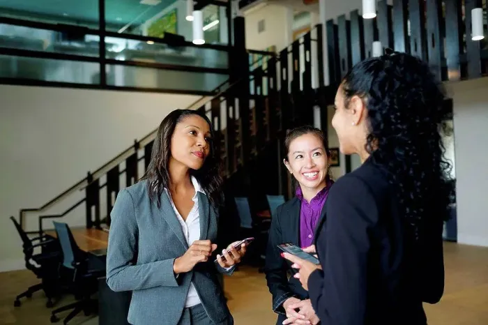 Framed Print : Three businesswomen standing in office, in conversation Framed Print : Three businesswomen standing in office, in conversation