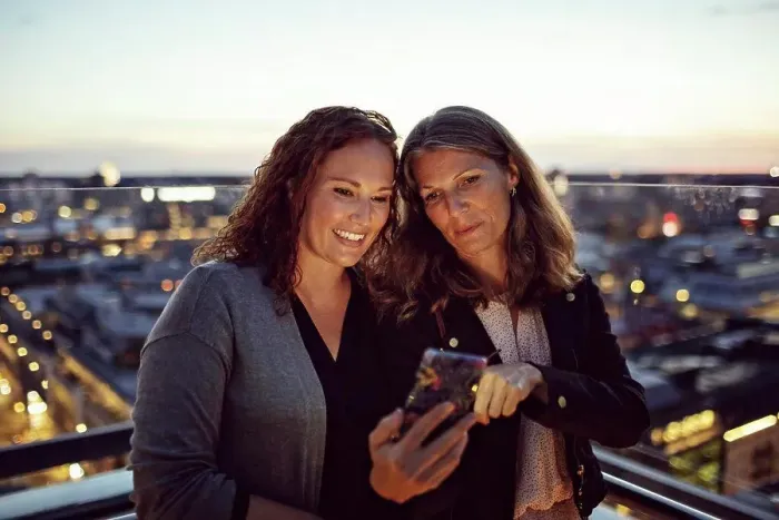 Framed Print : Businesswomen taking selfie on smart phone while standing on terrace after work Framed Print : Businesswomen taking selfie on smart phone while standing on terrace after work