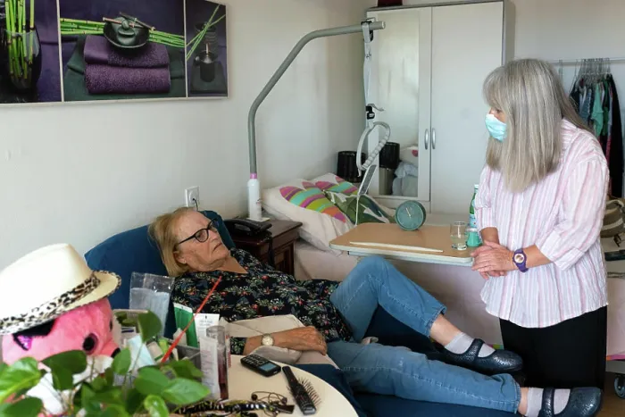 Framed Print : Caregiver in a retirement home looking after a septuagenarian with Parkinson's to do her cooking and cleaning Framed Print : Caregiver in a retirement home looking after a septuagenarian with Parkinson's to do her cooking and cleaning