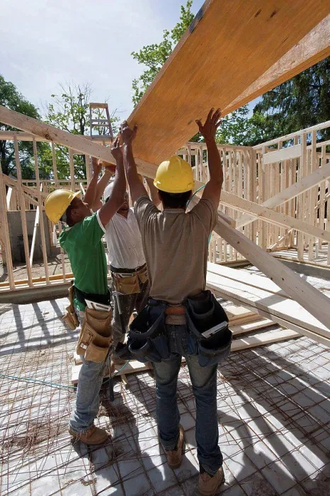 Framed Print : Carpenters lifting a laminated beam at a construction site Framed Print : Carpenters lifting a laminated beam at a construction site