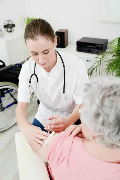 Framed Print : Cheerful young woman doctor giving vaccine injection to elderly woman at home Framed Print : Cheerful young woman doctor giving vaccine injection to elderly woman at home