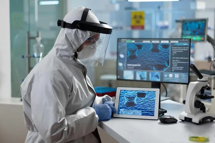 Framed Print : Chemist researcher wearing covid19 protective equipment looking at tablet Framed Print : Chemist researcher wearing covid19 protective equipment looking at tablet