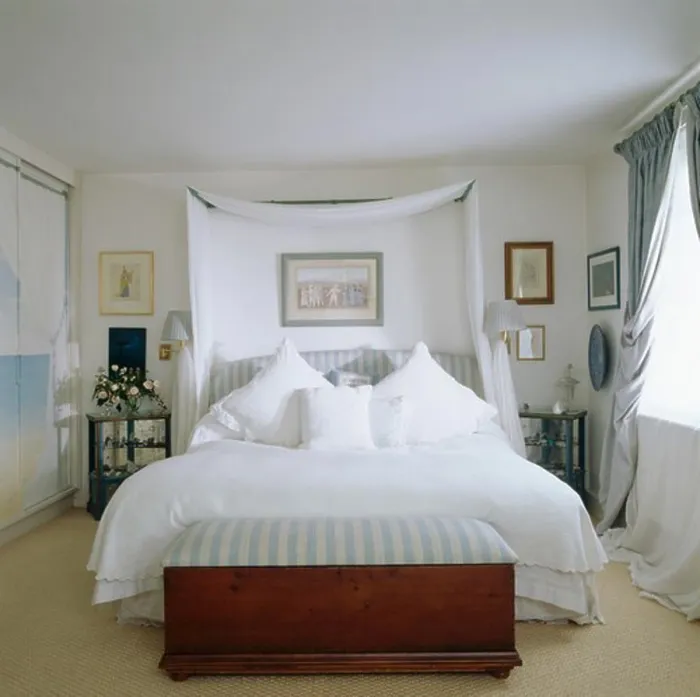 Framed Print : Chest below bed with white linen and drapes in white bedroom Framed Print : Chest below bed with white linen and drapes in white bedroom