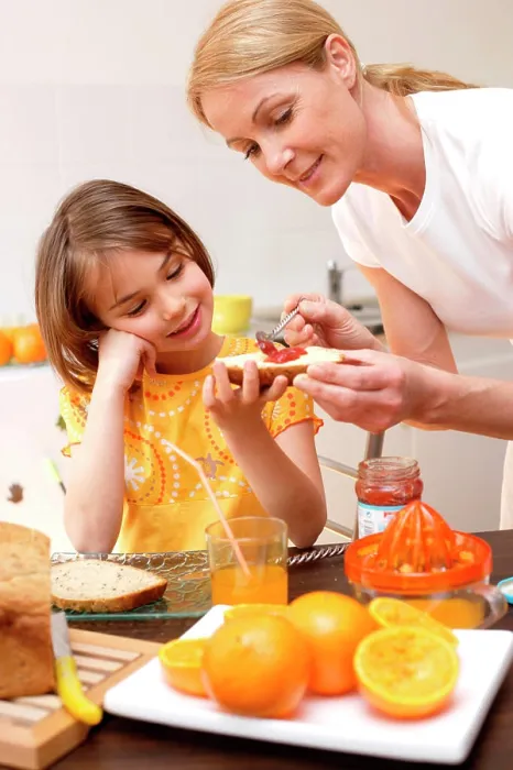 Framed Print : Child having breakfast or snack with her mother Framed Print : Child having breakfast or snack with her mother