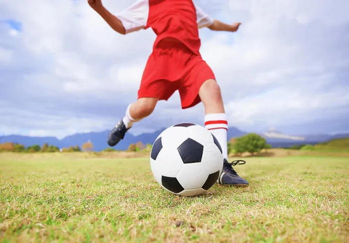 Framed Print : Child, kicking and soccer ball on green grass for sports