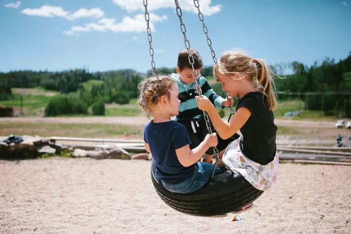 Framed Print : Children swing on tire on playset in mountains in sunshine Framed Print : Children swing on tire on playset in mountains in sunshine