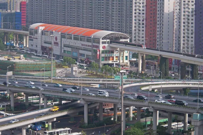 Framed Print : China, Shanghai, Light Railway train leaving Caoxi Road station in south Shanghai in the early morning with cars