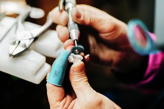 Framed Print : Close up of jewelers hands sanding with handheld bench grinder Framed Print : Close up of jewelers hands sanding with handheld bench grinder