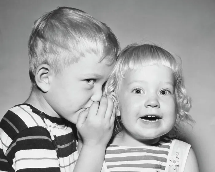 Framed Print : Close-up of a boy whispering to his sister Framed Print : Close-up of a boy whispering to his sister