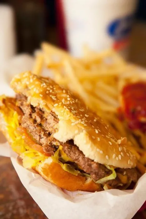 Framed Print : Close-up of a half eaten hamburger with fries in the background Framed Print : Close-up of a half eaten hamburger with fries in the background