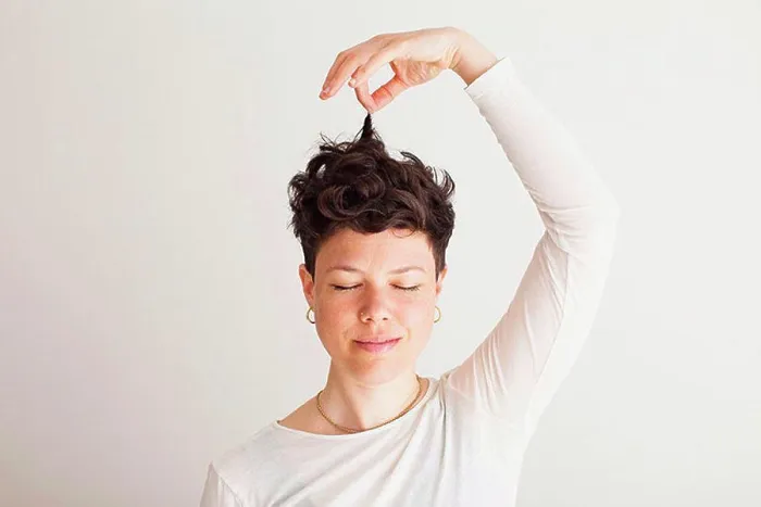 Framed Print : Close-up of happy mid adult woman holding her hair against white background Framed Print : Close-up of happy mid adult woman holding her hair against white background