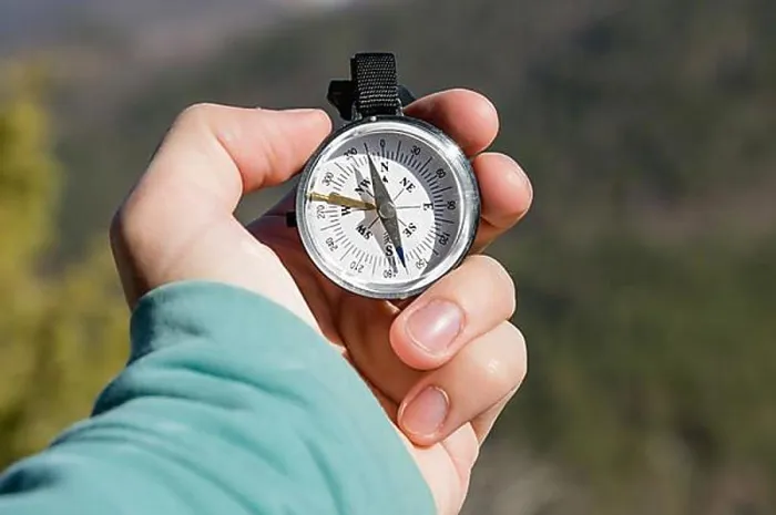Framed Print : Close-up A man's hand holds a pocket compass against the backdrop of mountains and woods Framed Print : Close-up A man's hand holds a pocket compass against the backdrop of mountains and woods