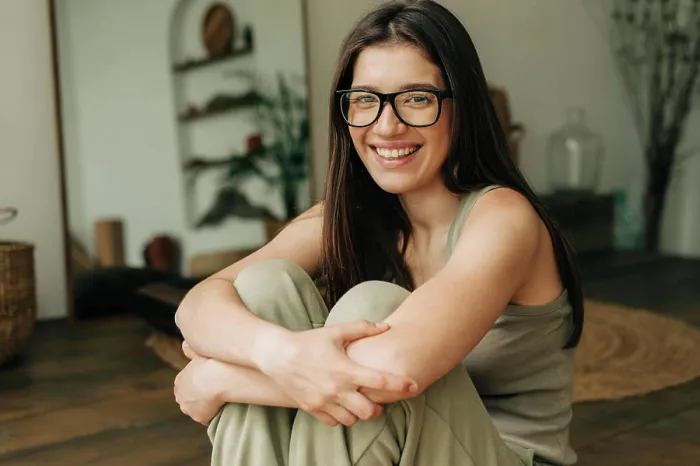 Framed Print : Close-up portrait of a beautiful happy brunette woman in glasses sitting on the floor Framed Print : Close-up portrait of a beautiful happy brunette woman in glasses sitting on the floor