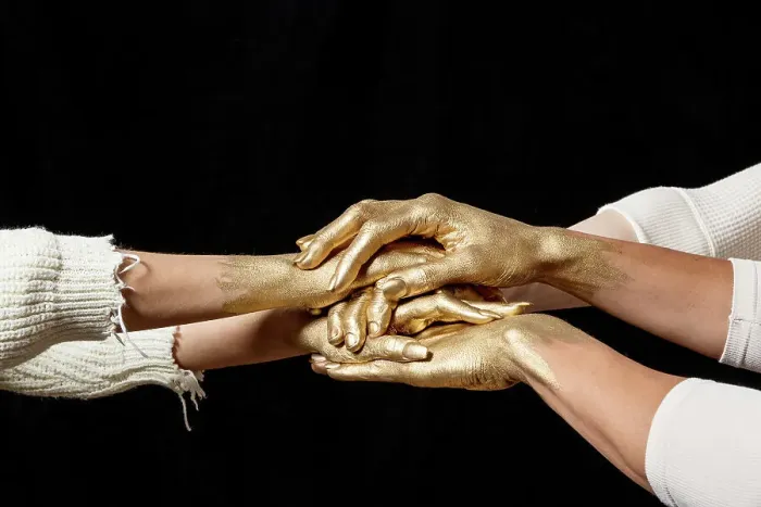 Framed Print : Yes. Close-up shot of group's gold painted hands on top of another against Framed Print : Yes. Close-up shot of group's gold painted hands on top of another against