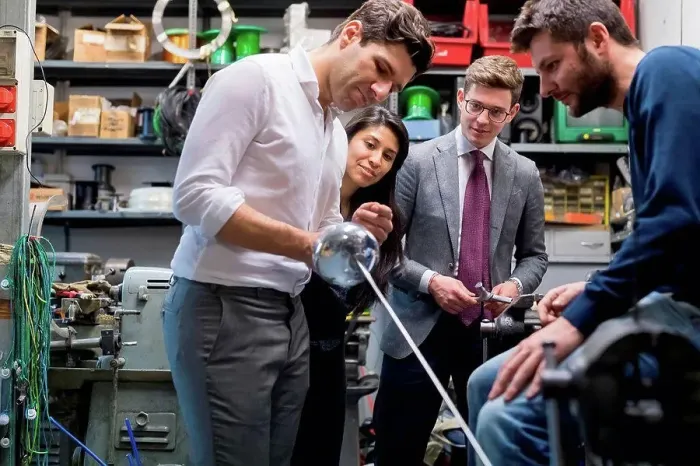 Framed Print : Colleagues in discussion in fencing prop workshop