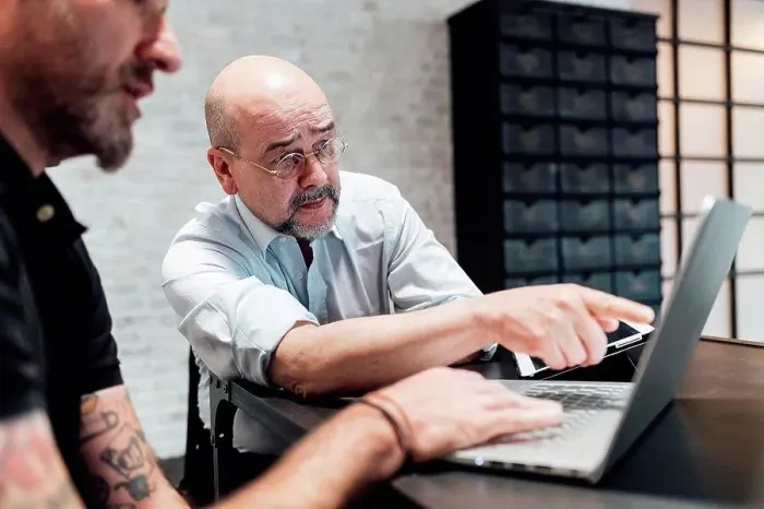 Framed Print : Colleagues looking at laptop together Framed Print : Colleagues looking at laptop together