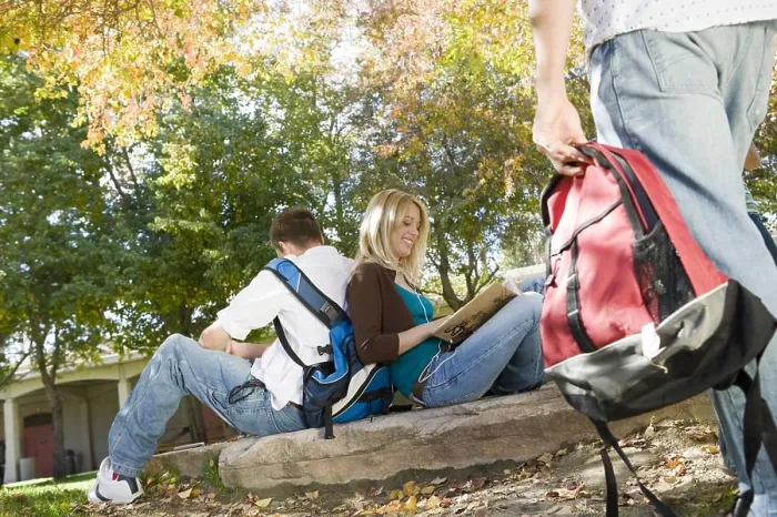 Framed Print : Two college friends sitting back to back at park