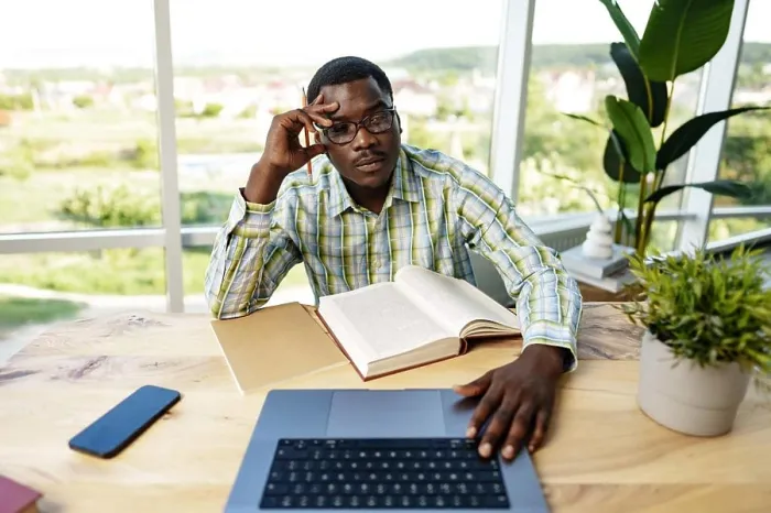 Framed Print : Serious concentrated african man studying or working with laptop indoors Framed Print : Serious concentrated african man studying or working with laptop indoors