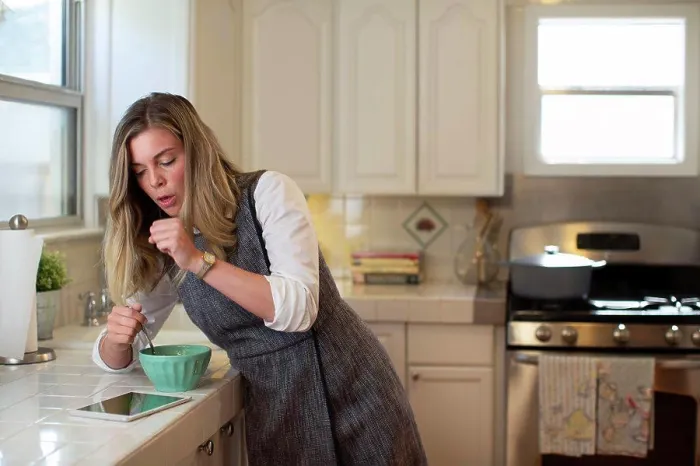 Framed Print : Coughing young woman in her kitchen, eating breakfast getting on her iPad Framed Print : Coughing young woman in her kitchen, eating breakfast getting on her iPad