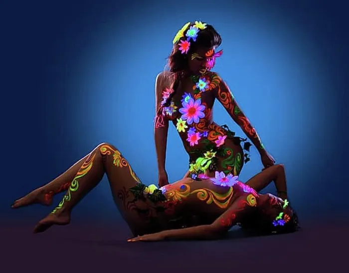 Framed Print : Couple of Naked women posing with glow ultraviolet body art and flowers
