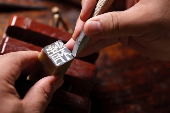 Framed Print : Craftsman carving Chinese character into a Chinese chop
